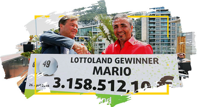 Ganador de Lotoland Mario sostiene cheque con su premio