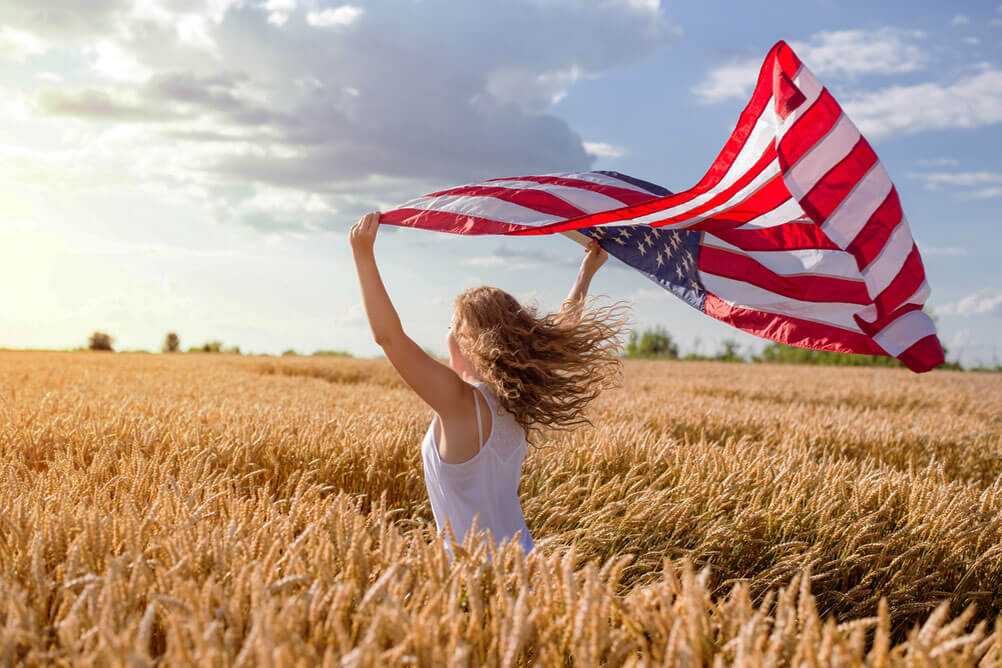 Mujer levanta bandera estadounidense y celebra el premio récord de PowerBall